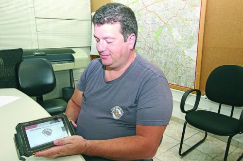 Major Ricardo mostra o tablet que os policiais utilizam nas viaturas 